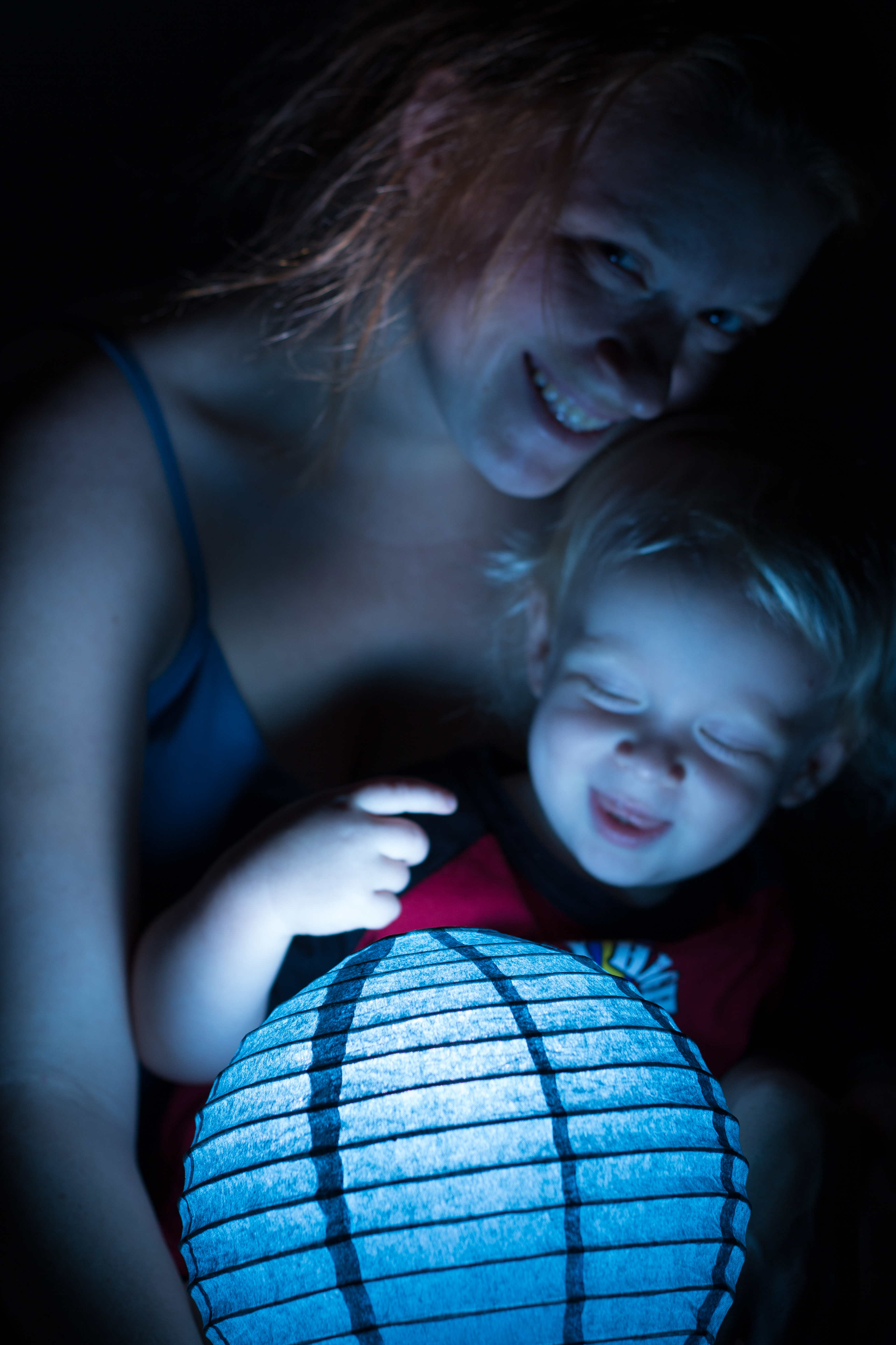 Illuminated paper lamp with woman holding young child