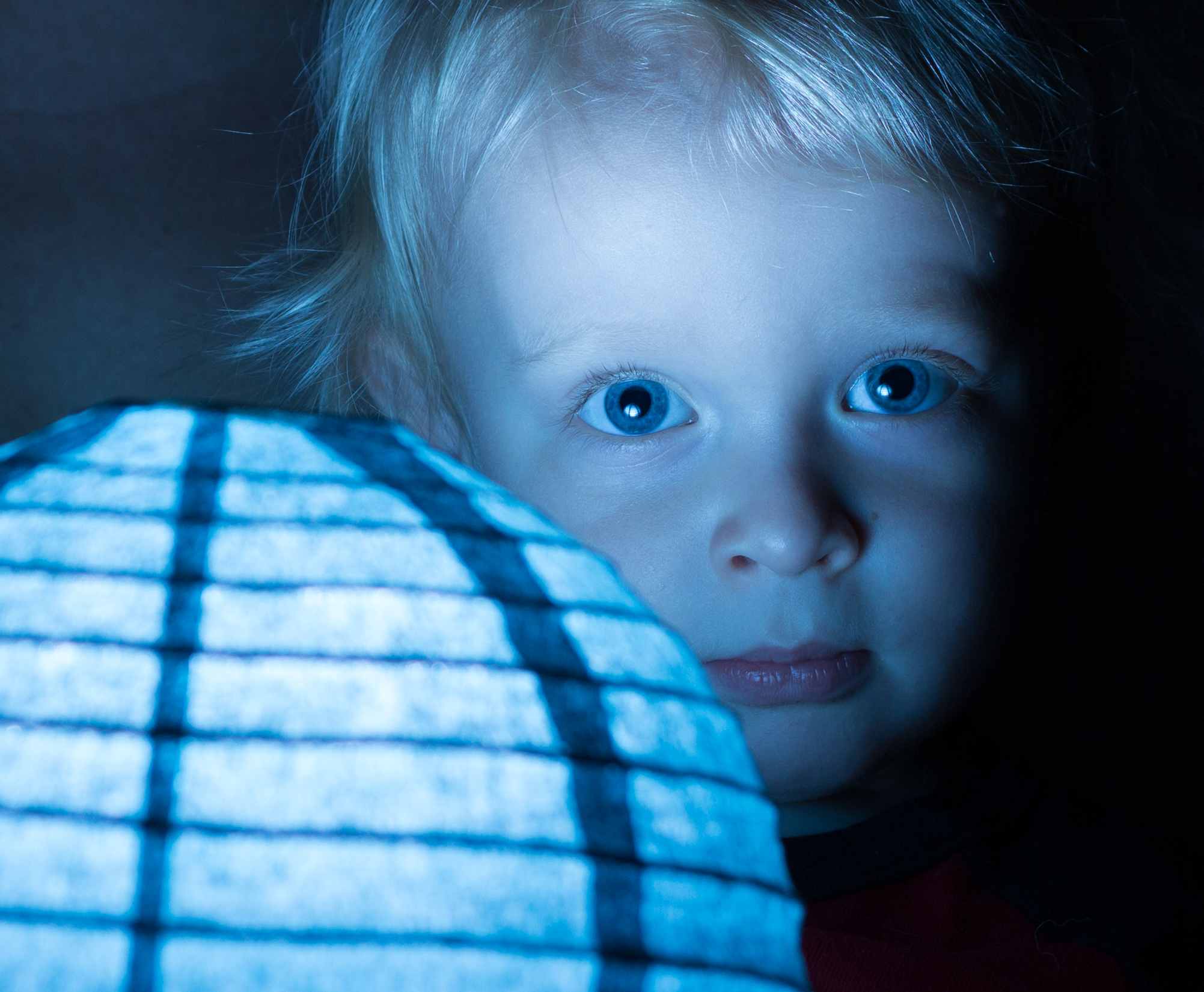 Child's face with reflections of glowing orb